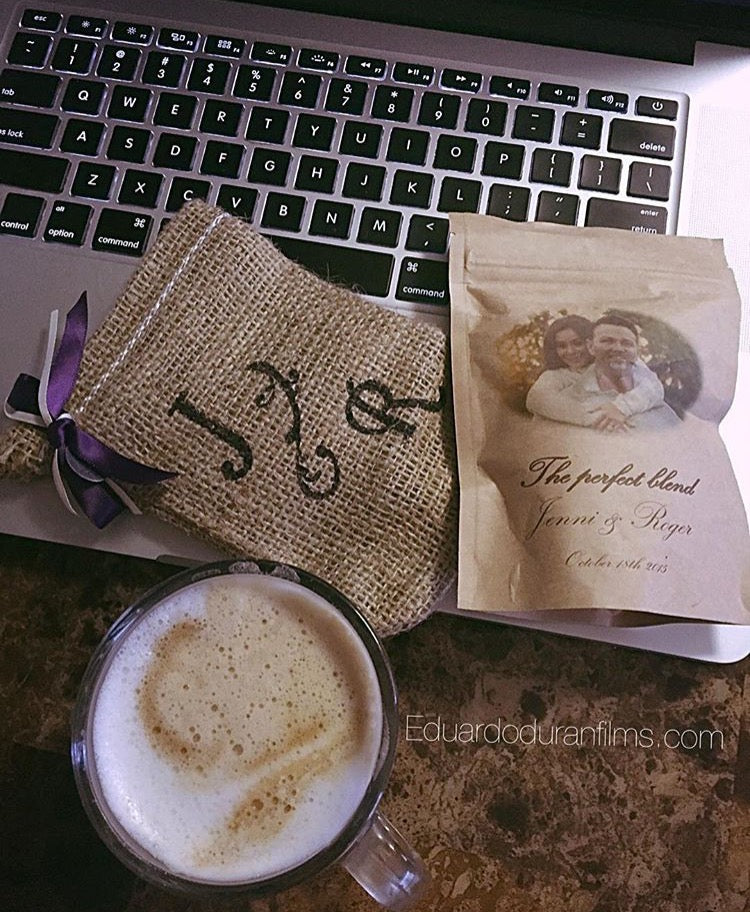 Two coffee bags with personalized designs on a laptop keyboard, next to a cup of coffee.